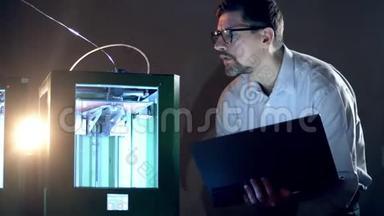 一个有笔记本电脑的人控制3D打印机。 三维印刷行业研究工程师在实验室工作。